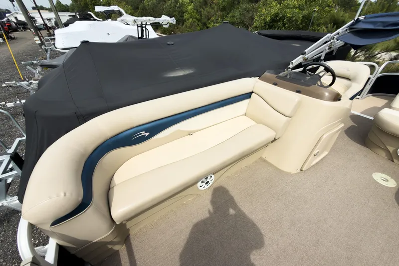 Slide: The Image of 2012 Bennington 22 SSL pontoon boat interior with beige seating and steering console. - 18