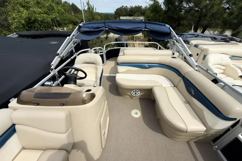 Slide: The Image of 2012 Bennington 22 SSL pontoon boat with beige seating and blue accents. - 20