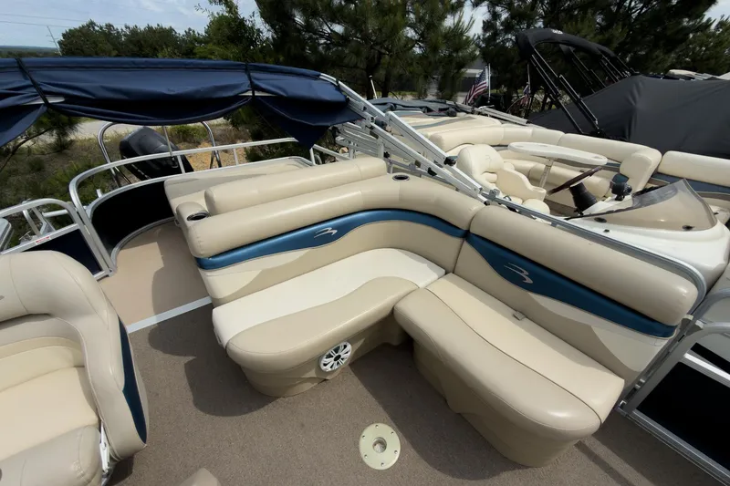 Slide: The Image of 2012 Bennington 22 SSL pontoon boat with beige and blue seating, spacious deck, and canopy. - 21
