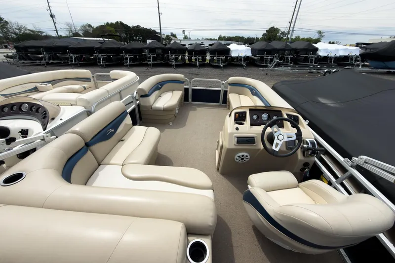 Slide: The Image of 2012 Bennington 22 SSL pontoon boat interior with beige seating and steering console. - 25