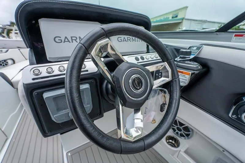 Slide: The Image of Steering wheel and dashboard of 2026 Crownline 318 XSS boat with Garmin navigation. - 21