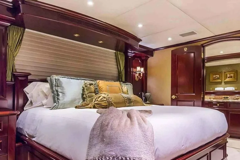 Slide: The Image of Luxurious bedroom interior on 2003 Trinity Yachts Motoryacht, featuring elegant wood finishes and plush bedding. - 22