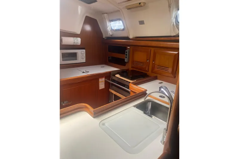 Slide: The Image of Interior view of 2002 Beneteau Oceanis Clipper 361 yacht kitchen with wooden cabinetry. - 10