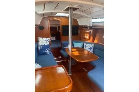 Slide: The Image of Interior of 2002 Beneteau Oceanis Clipper 361 yacht with blue seating and wooden table. - 13