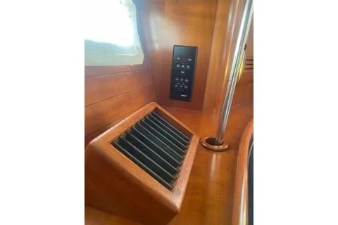 Slide: The Image of Interior of 2002 Beneteau Oceanis Clipper 361 yacht, featuring wooden paneling and control panel. - 16