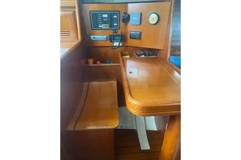 Slide: The Image of 2002 Beneteau Oceanis Clipper 361 interior navigation station with wooden finish and control panel. - 18