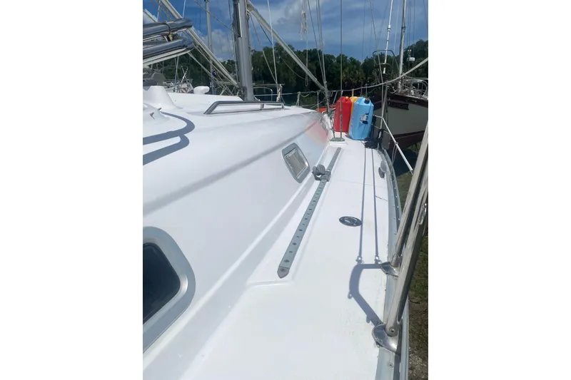 Slide: The Image of 2002 Beneteau Oceanis Clipper 361 sailboat deck with clear skies and docked surroundings. - 2