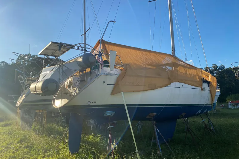 Slide: The Image of 2002 Beneteau Oceanis Clipper 361 sailboat on land, covered with tarp, sunny day. - 34