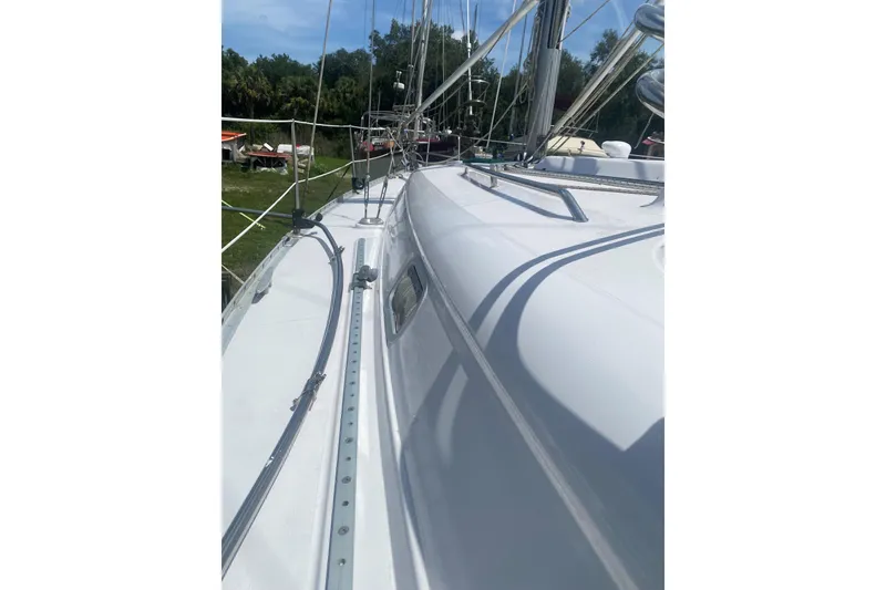 Slide: The Image of 2002 Beneteau Oceanis Clipper 361 sailboat deck view with rigging and lush surroundings. - 35