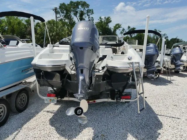 Slide: The Image of 2016 Stingray 214 LR boat with outboard motor on gravel lot. - 4