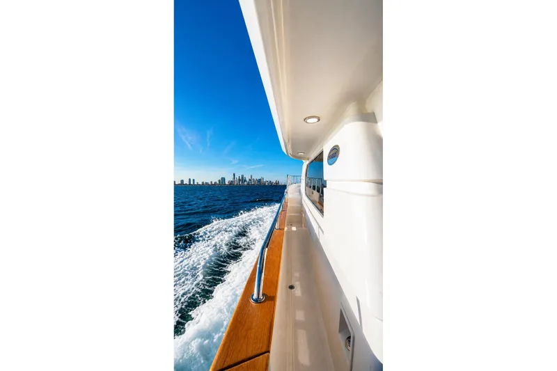 Slide: The Image of Side view of a 2005 Symbol 58 Pilothouse yacht cruising with city skyline in background. - 15