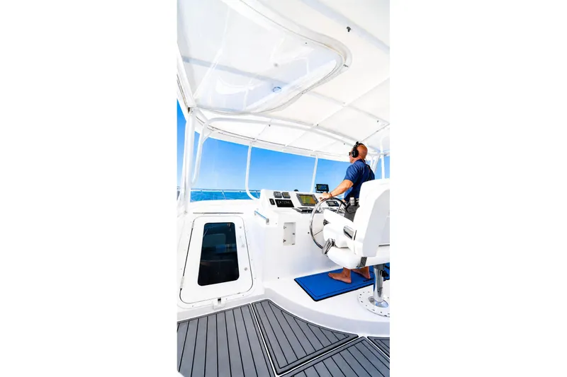 Slide: The Image of Person steering a 2005 Symbol 58 Pilothouse yacht on open water. - 16