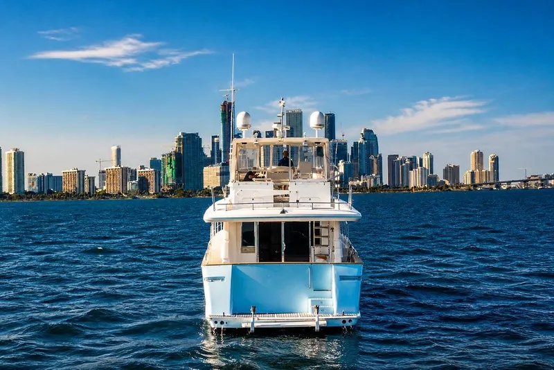 Slide: The Image of Luxury yacht Symbol 58 Pilothouse 2005 on water with city skyline backdrop. - 3