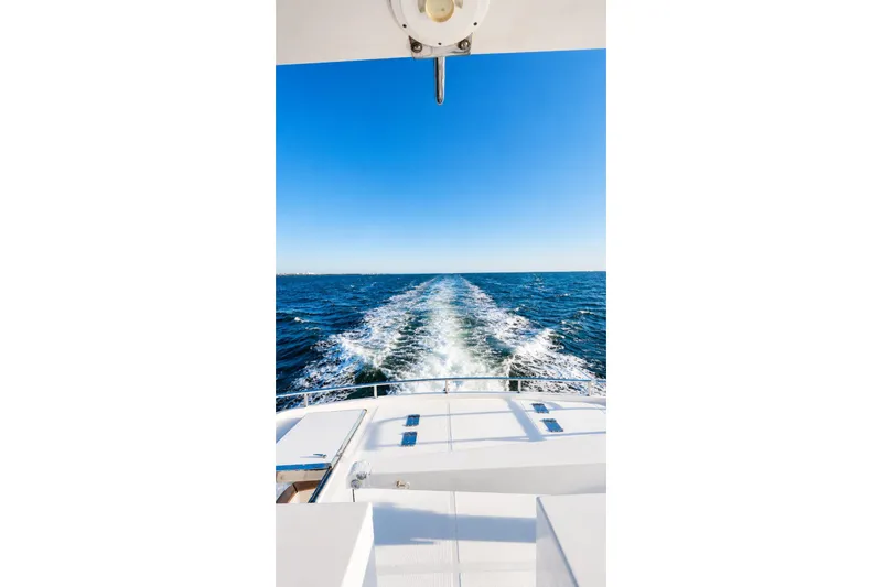 Slide: The Image of Wake trail behind 2005 Symbol 58 Pilothouse yacht on open sea under clear blue sky. - 36