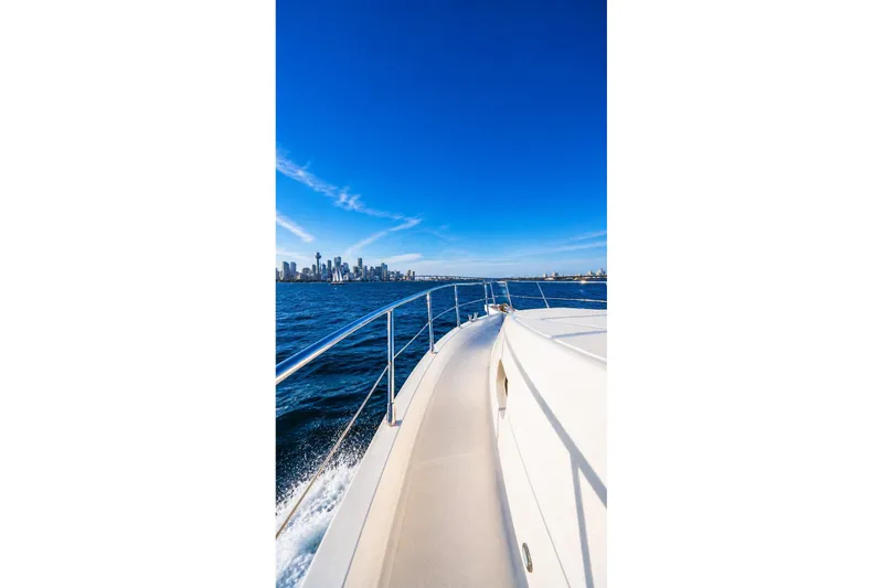 Slide: The Image of Bow of 2005 Symbol 58 Pilothouse yacht cruising towards city skyline under clear blue sky. - 39