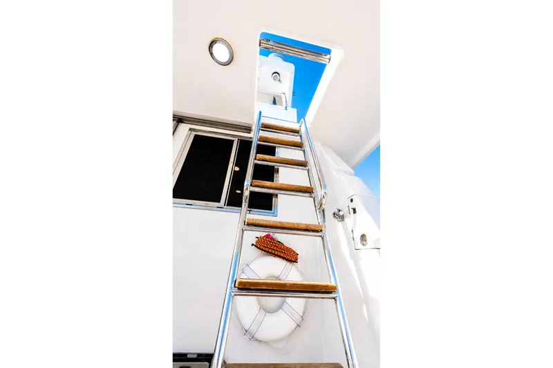 Slide: The Image of Ladder on 2005 Symbol 58 Pilothouse yacht with life preserver and clear sky. - 43