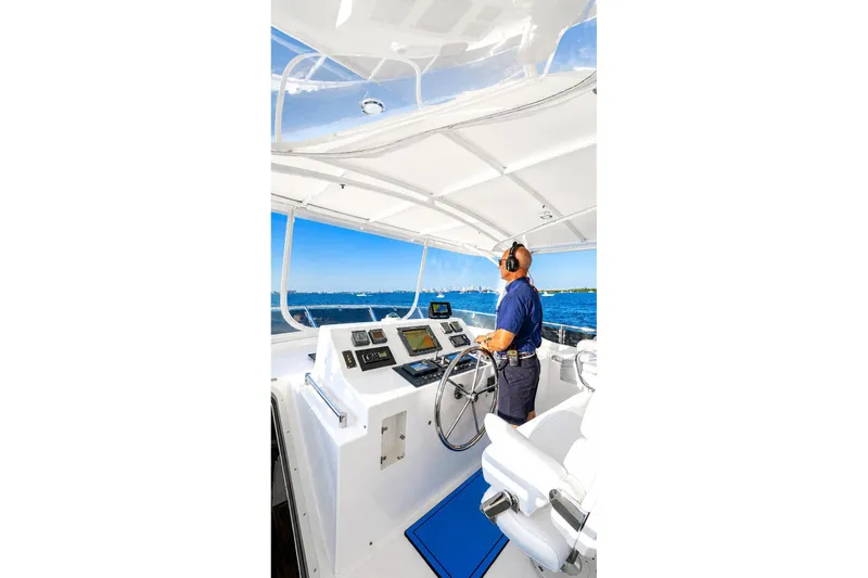 Slide: The Image of Person steering a 2005 Symbol 58 Pilothouse yacht on open water. - 44