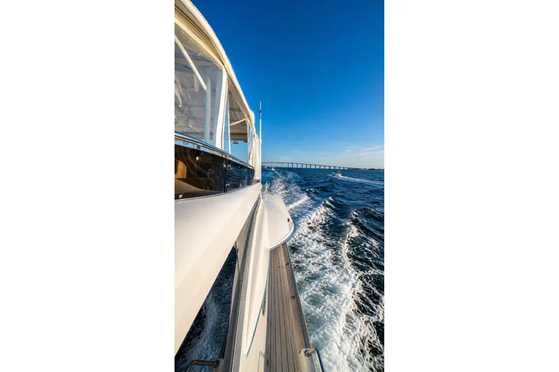 Slide: The Image of Side view of a 2005 Symbol 58 Pilothouse yacht cruising on open water. - 56