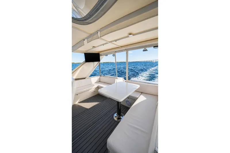 Slide: The Image of Luxurious 2005 Symbol 58 Pilothouse yacht interior with ocean view and seating area. - 57