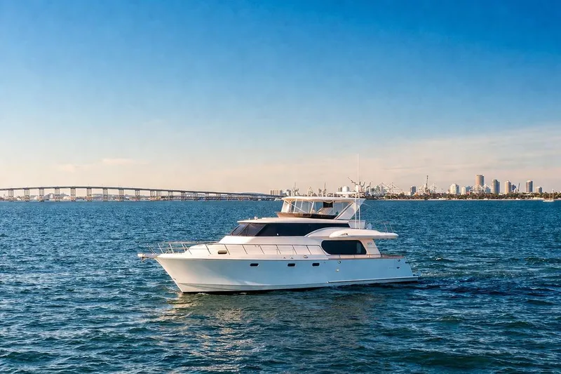 Slide: The Image of 2005 Symbol 58 Pilothouse yacht cruising on blue ocean with city skyline backdrop. - 9