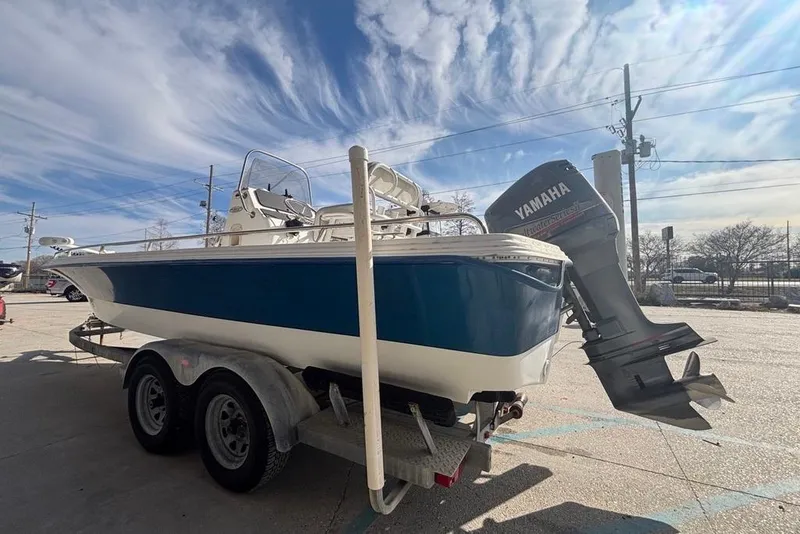 Slide: The Image of 2001 Bay Stealth 2230 boat with Yamaha outboard motor on trailer under blue sky. - 3
