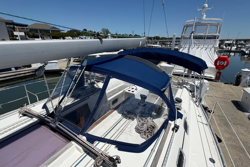 Slide: The Image of 1998 Jeanneau Sun Odyssey 45.2 sailboat docked at marina, featuring blue canopy and sleek design. - 10
