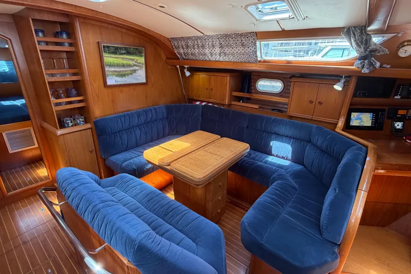 Slide: The Image of Luxurious interior of 1998 Jeanneau Sun Odyssey 45.2 yacht with plush blue seating and wooden accents. - 34