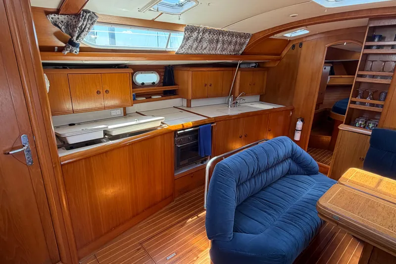 Slide: The Image of Interior of 1998 Jeanneau Sun Odyssey 45.2 yacht with wooden cabinetry and blue seating. - 36