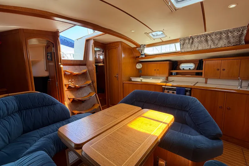 Slide: The Image of Interior of 1998 Jeanneau Sun Odyssey 45.2 yacht with wooden furnishings and blue seating. - 38