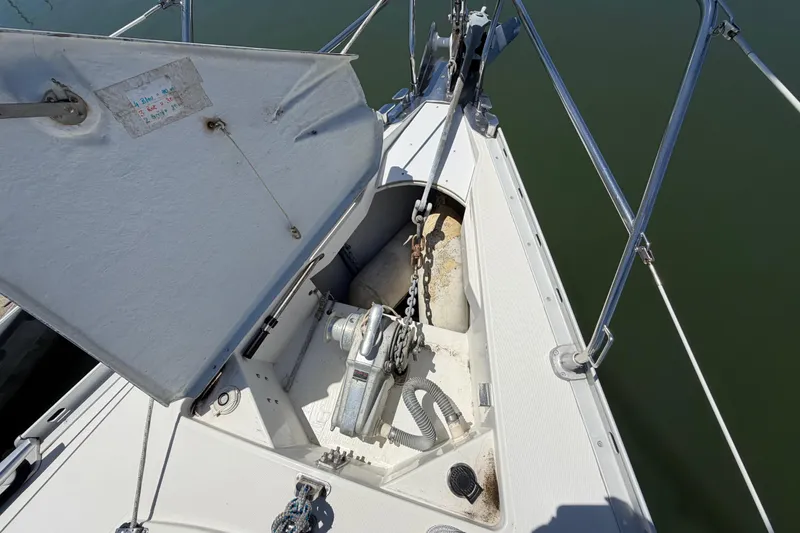 Slide: The Image of Anchor locker of a 1998 Jeanneau Sun Odyssey 45.2 sailboat, featuring chain and winch. - 4