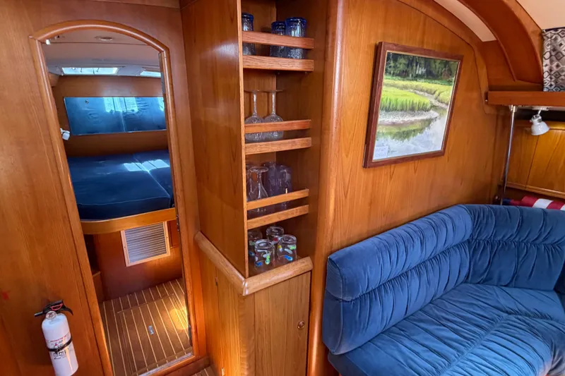 Slide: The Image of Interior of 1998 Jeanneau Sun Odyssey 45.2 yacht with cozy seating and wooden cabinetry. - 40