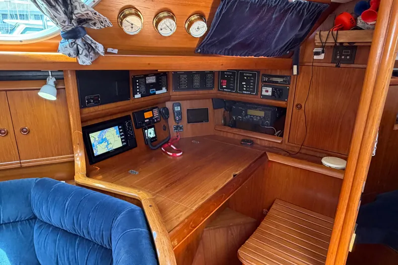 Slide: The Image of Navigation station of a 1998 Jeanneau Sun Odyssey 45.2 sailboat, featuring wooden interior and instruments. - 42