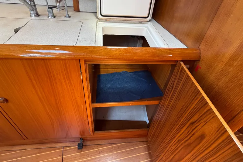 Slide: The Image of Wooden interior of 1998 Jeanneau Sun Odyssey 45.2 yacht, featuring open cabinet and sink. - 66