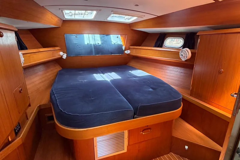 Slide: The Image of Cozy cabin interior of 1998 Jeanneau Sun Odyssey 45.2 with wooden finish and blue bedding. - 68