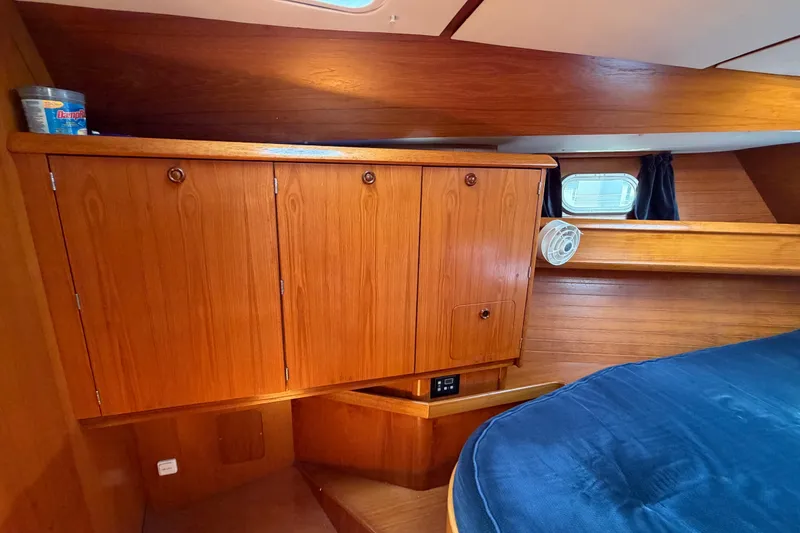 Slide: The Image of Interior cabin of 1998 Jeanneau Sun Odyssey 45.2 with wooden cabinetry and blue bedding. - 69