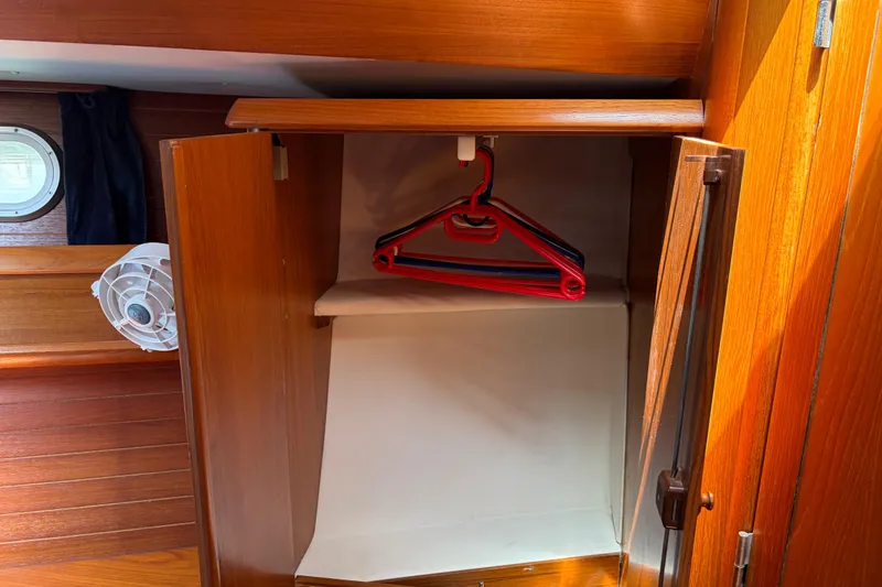 Slide: The Image of Wooden closet interior on a 1998 Jeanneau Sun Odyssey 45.2 yacht with hangers. - 72