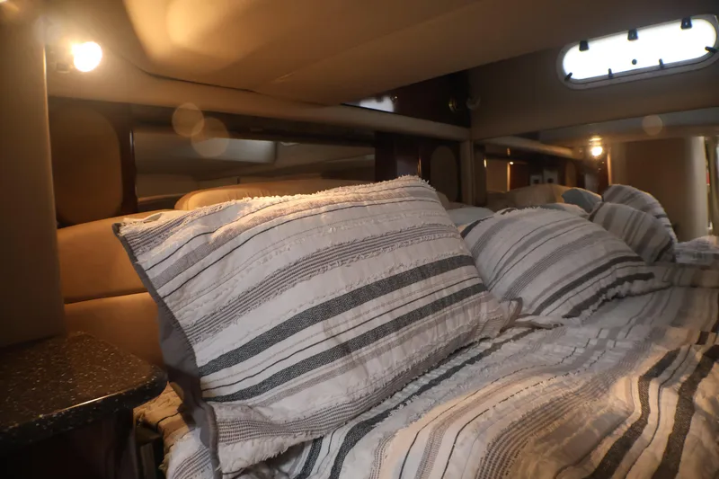 Slide: The Image of Cozy cabin interior of a 2003 Formula 400 Super Sport boat with striped bedding. - 17