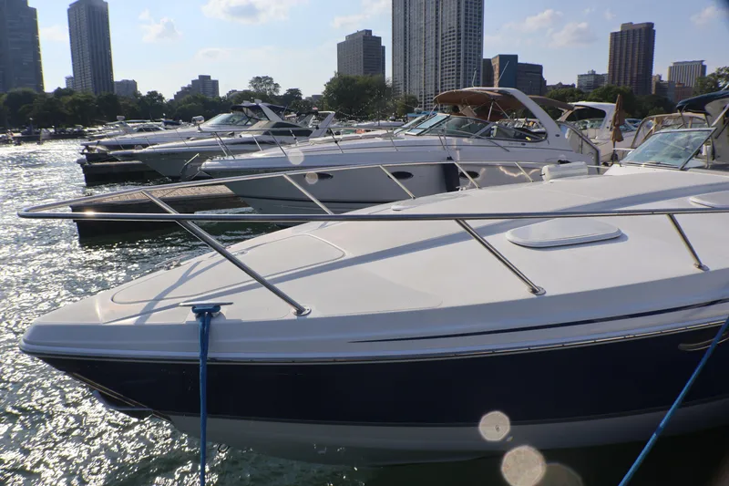 Slide: The Image of 2003 Formula 400 Super Sport boat docked in a marina with city skyline. - 2