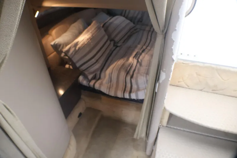 Slide: The Image of Cozy cabin interior of 2003 Formula 400 Super Sport with striped bedding. - 21