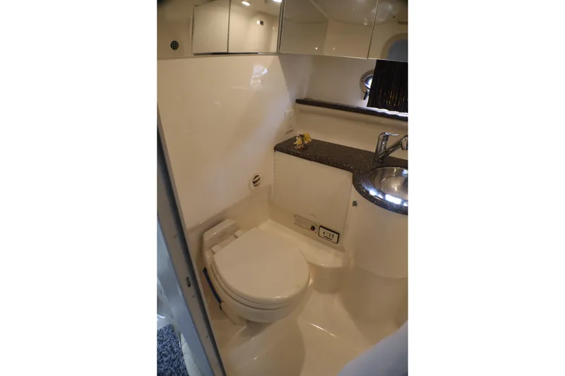 Slide: The Image of Compact bathroom in a 2003 Formula 400 Super Sport boat, featuring a toilet and sink. - 32