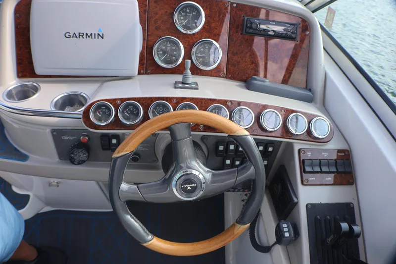 Slide: The Image of 2003 Formula 400 Super Sport boat dashboard with Garmin GPS and wooden steering wheel. - 44