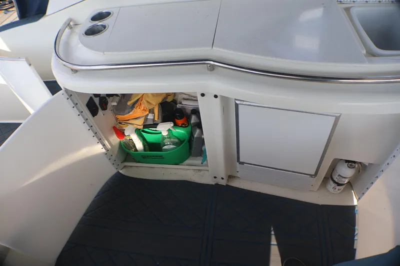Slide: The Image of Open storage compartment on 2003 Formula 400 Super Sport boat with cleaning supplies. - 53