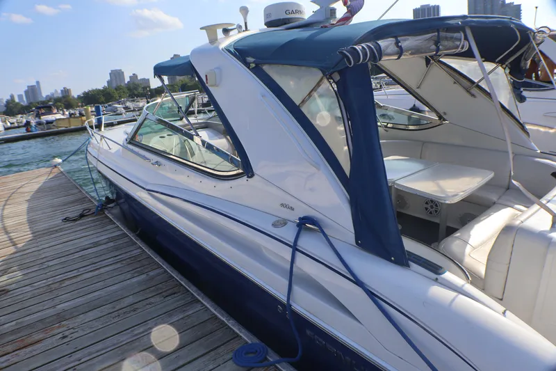 Slide: The Image of 2003 Formula 400 Super Sport boat docked at marina with blue canopy. - 8