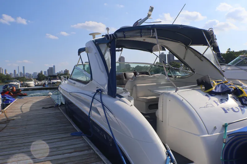 Slide: The Image of 2003 Formula 400 Super Sport yacht docked at marina with city skyline in background. - 9