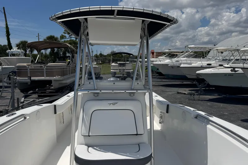 Slide: The Image of 2011 Tidewater 230 CC Adventure boat with T-top, docked among other vessels. - 23
