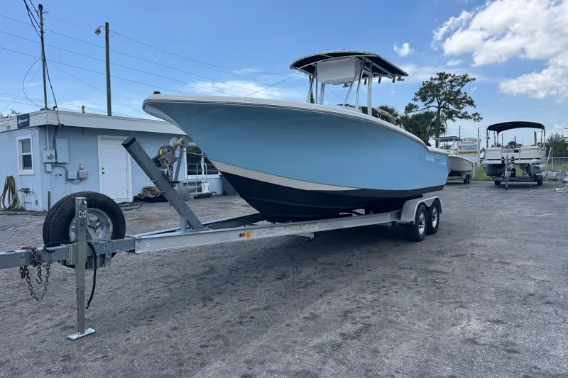 Slide: The Image of 2011 Tidewater 230 CC Adventure boat on trailer, parked outdoors under blue sky. - 3