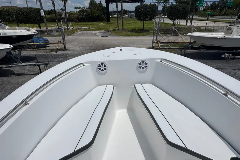 Slide: The Image of Bow seating area of 2011 Tidewater 230 CC Adventure boat, featuring white cushions and speakers. - 7