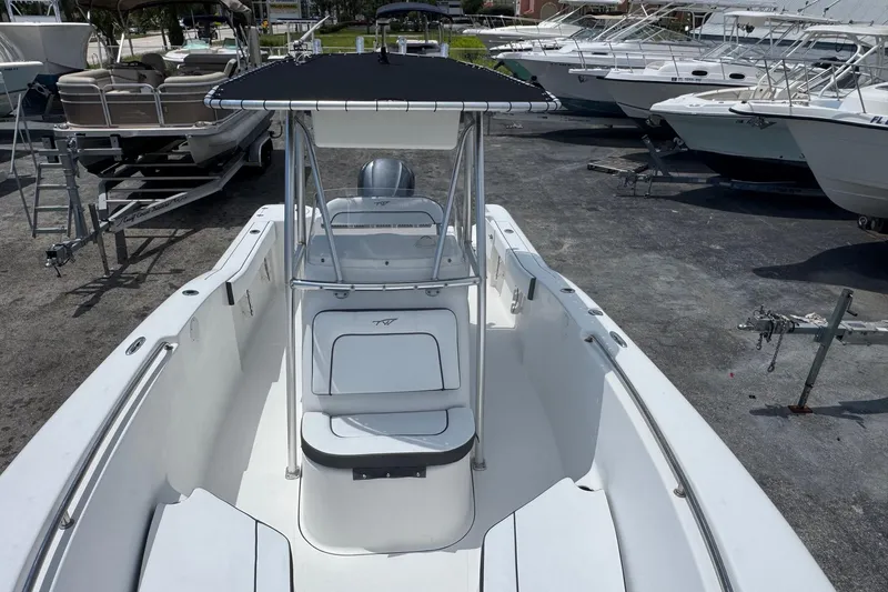 Slide: The Image of 2011 Tidewater 230 CC Adventure boat with T-top, parked among other boats. - 8