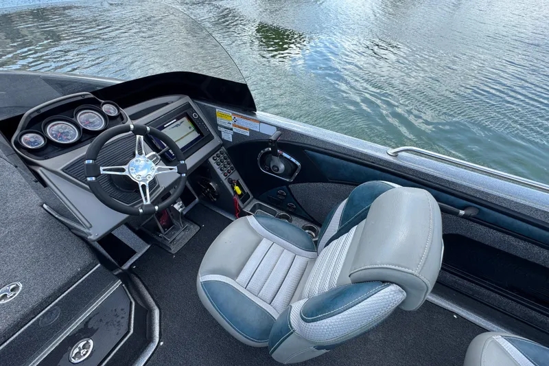 Slide: The Image of 2020 Ranger 2080MS Angler boat interior with steering wheel and dashboard by the water. - 18