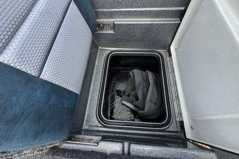 Slide: The Image of Storage compartment in 2020 Ranger 2080MS Angler boat with a backpack inside. - 23